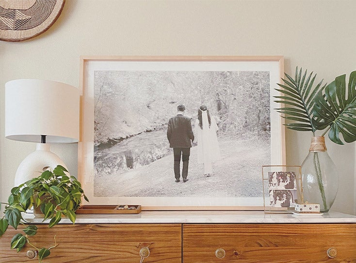 Large Artifact Uprising Gallery Frame with wedding photo atop mantle filled with plants and decor