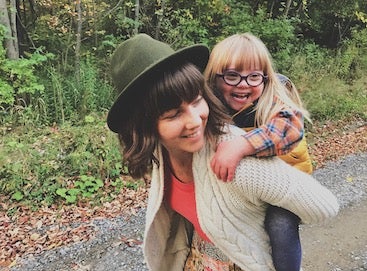 Mom giving daughter a piggyback ride