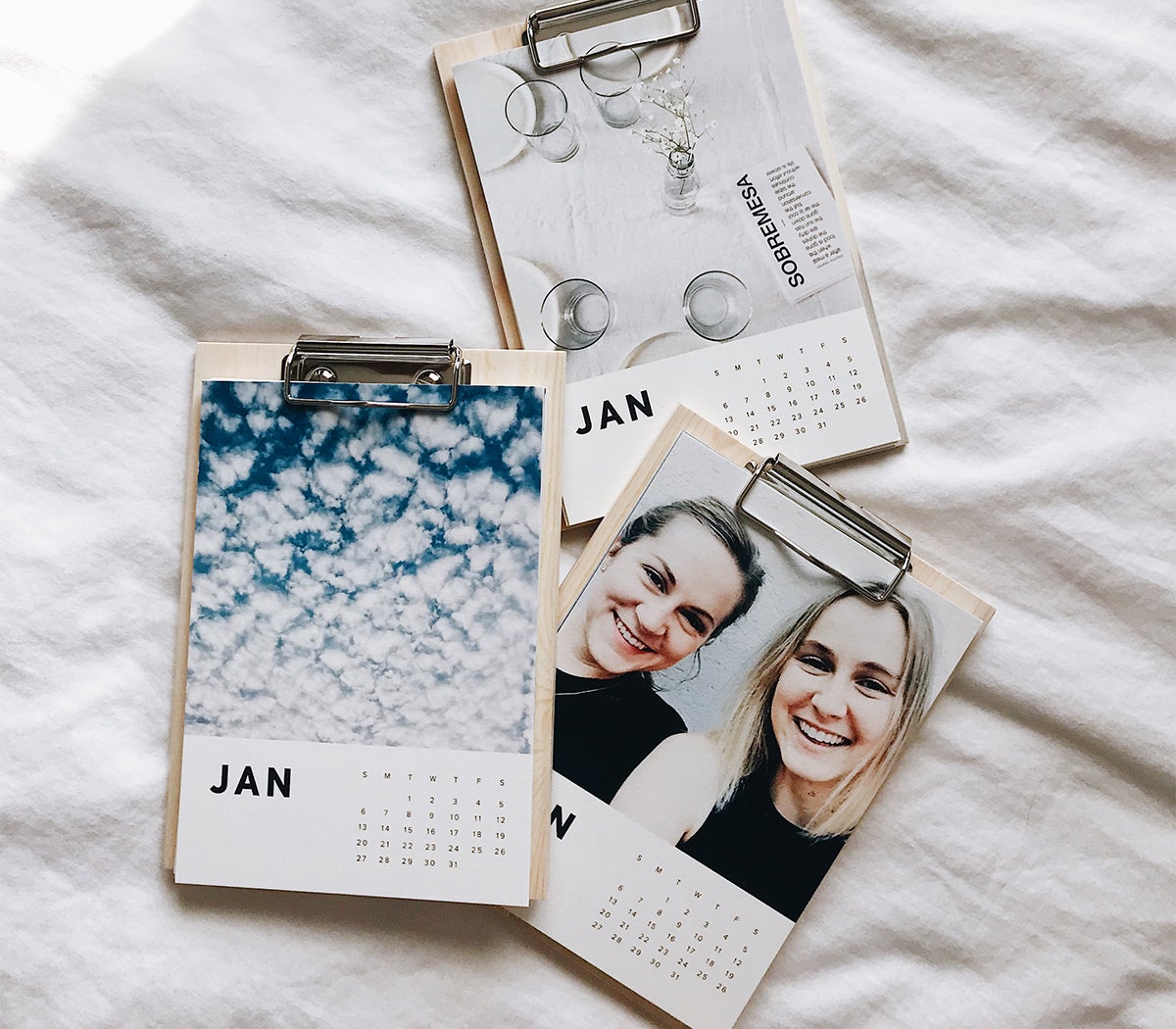 Photo of three Artifact Uprising Wood Calendars on bed by @brookeshanae