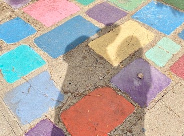 shadow of couple cast onto colorful stone paving