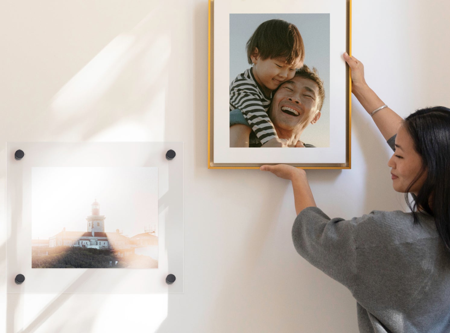 Woman hanging photo of newborn baby on wall