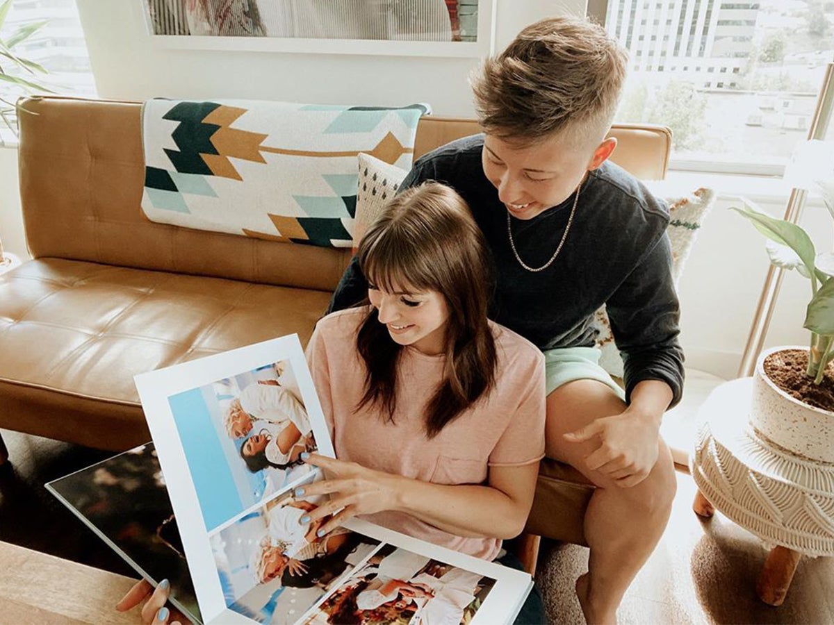 Couple flipping through their wedding album on the couch